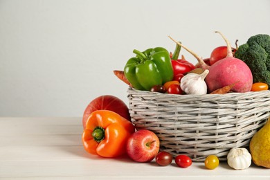 Photo of Assortment of fresh vegetables and fruits on white wooden table. Space for text