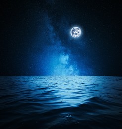 Picturesque starry sky with full moon over sea at night