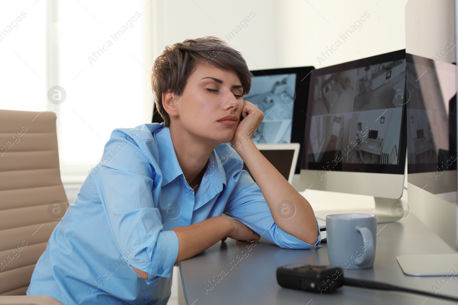 Photo of Female security guard sleeping at workplace indoors