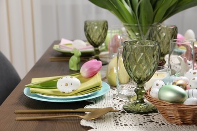 Photo of Festive table setting with painted eggs. Easter celebration