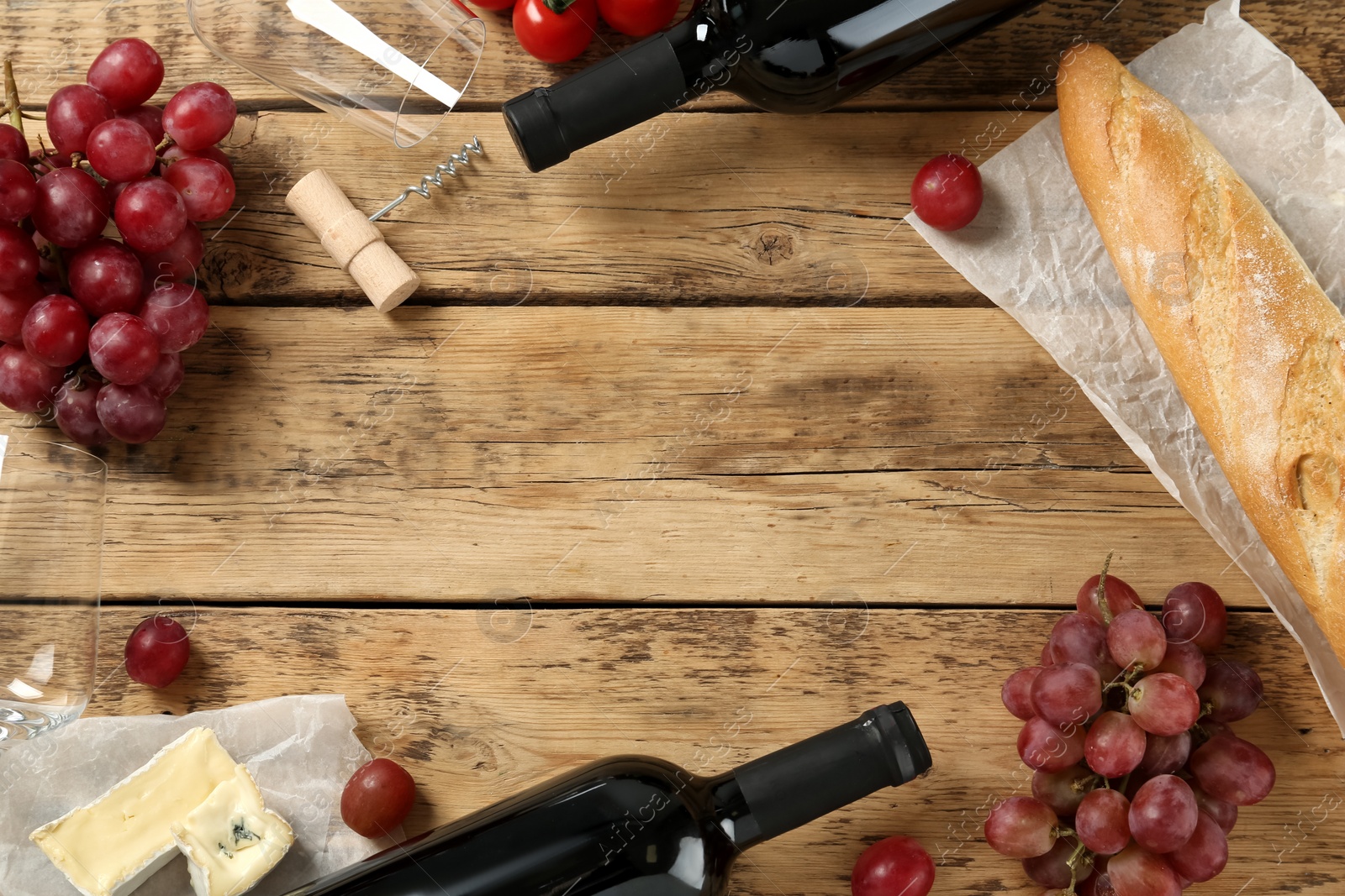 Photo of Flat lay composition with red wine and snacks on wooden table, space for text