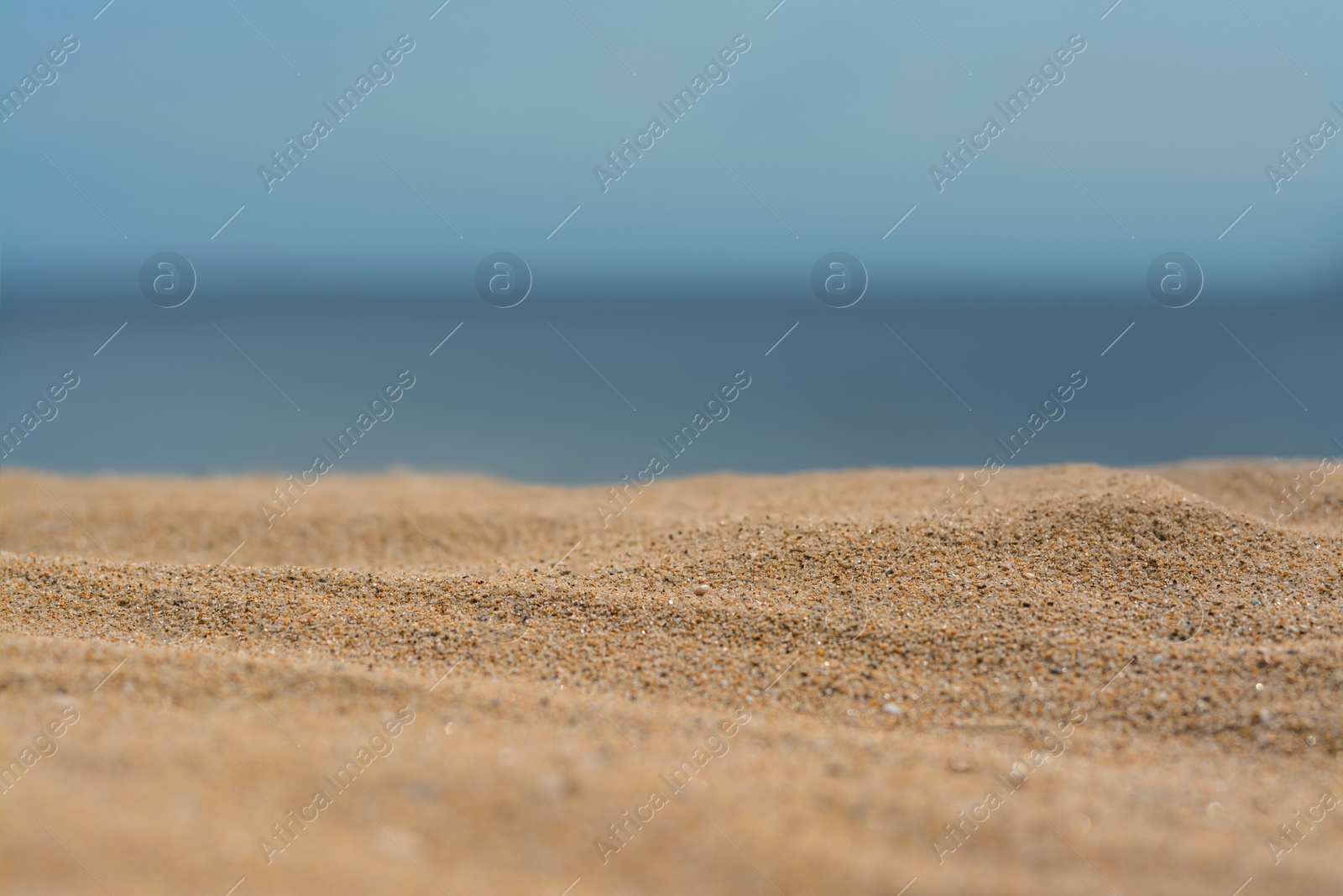 Photo of Closeup view of sandy beach near sea on sunny day