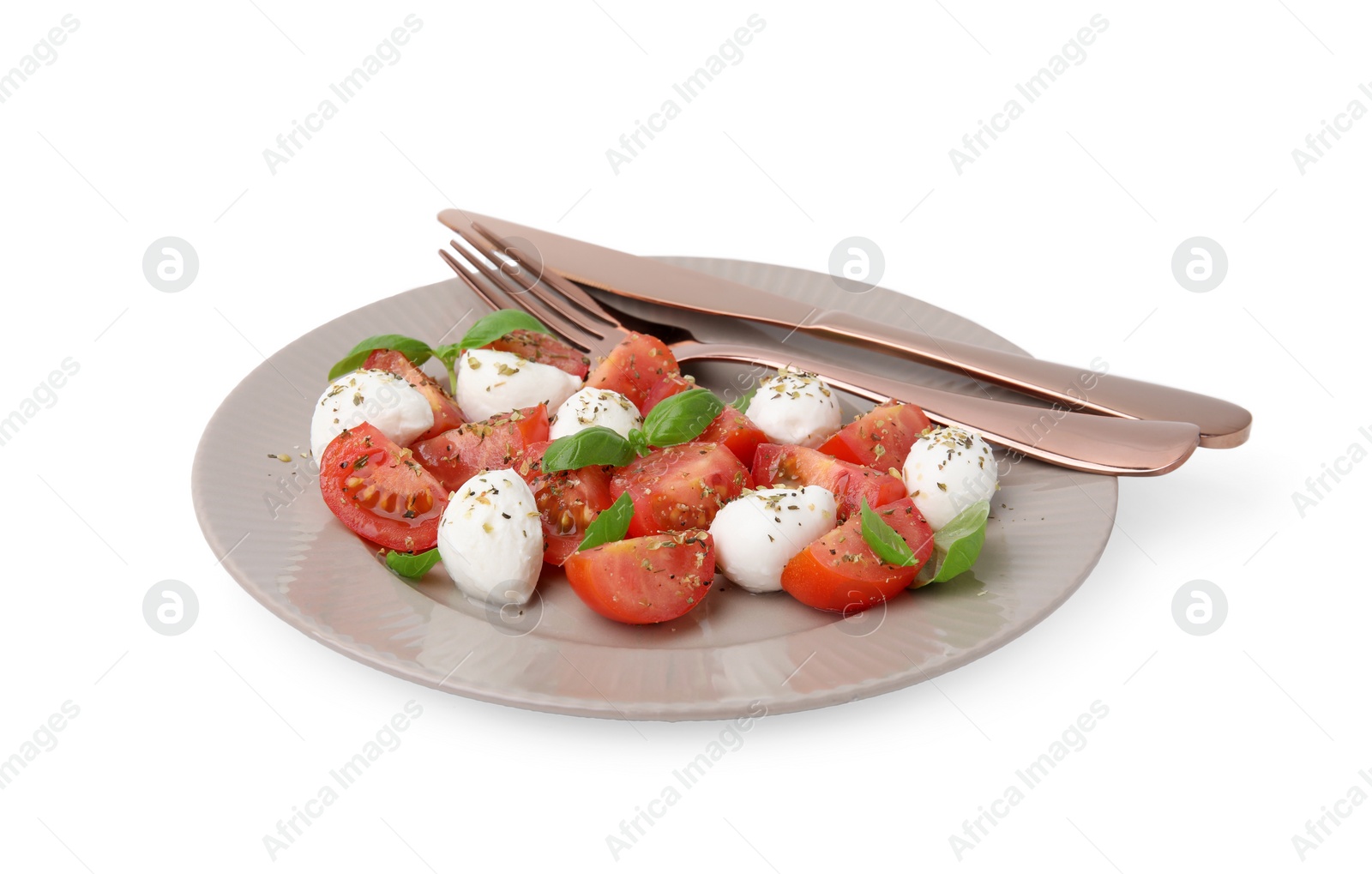 Photo of Plate of tasty salad Caprese with mozarella balls, tomatoes, basil and cutlery on white background