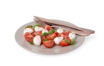 Photo of Plate of tasty salad Caprese with mozarella balls, tomatoes, basil and cutlery on white background