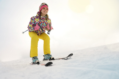 Photo of Young woman skiing on snowy hill. Winter vacation