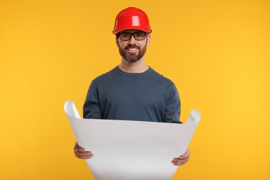 Photo of Architect in hard hat with draft on orange background