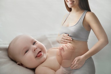 Image of Double exposure of pregnant woman and cute baby on light background