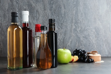 Photo of Composition with different kinds of vinegar and ingredients on table. Space for text