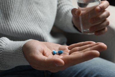 Photo of Man with glass of water and pills, closeup