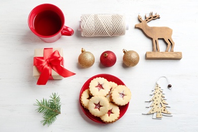 Photo of Christmas items and Linzer cookies with sweet jam on wooden background, top view