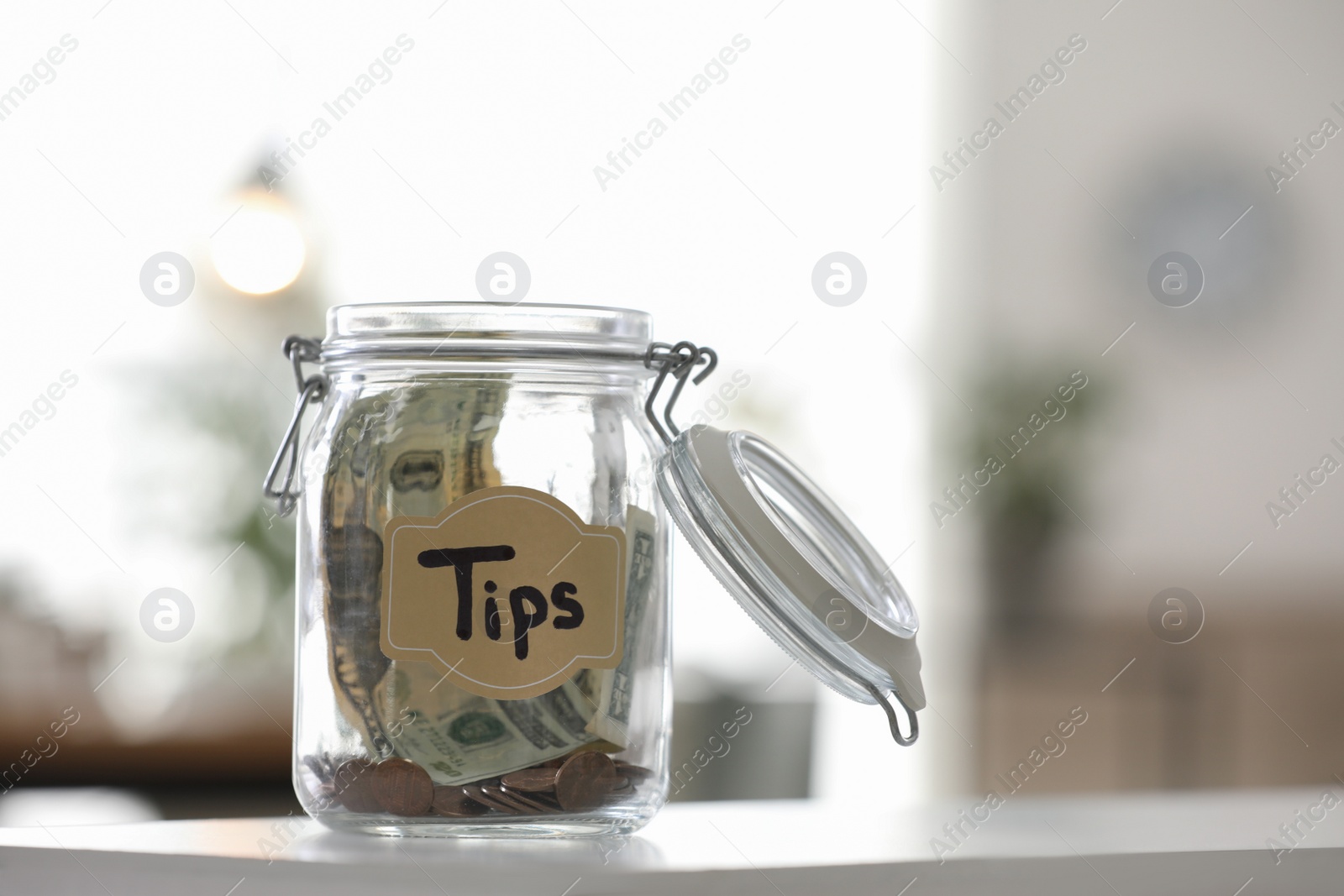 Photo of Glass jar with tips on table indoors