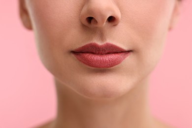 Photo of Woman with beautiful lips on pink background, closeup