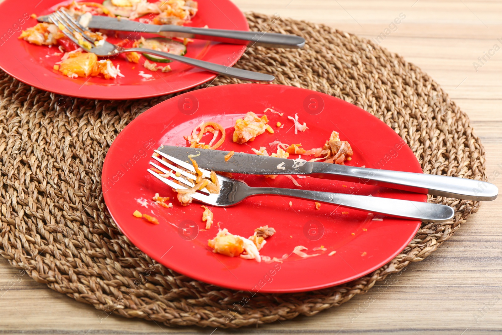 Photo of Dirty plates with leftovers on wooden table after party, closeup