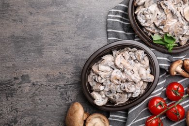 Flat lay composition with delicious cooked mushrooms on grey table. Space for text