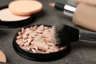 Photo of Powder with makeup brush on grey background. Skin foundation