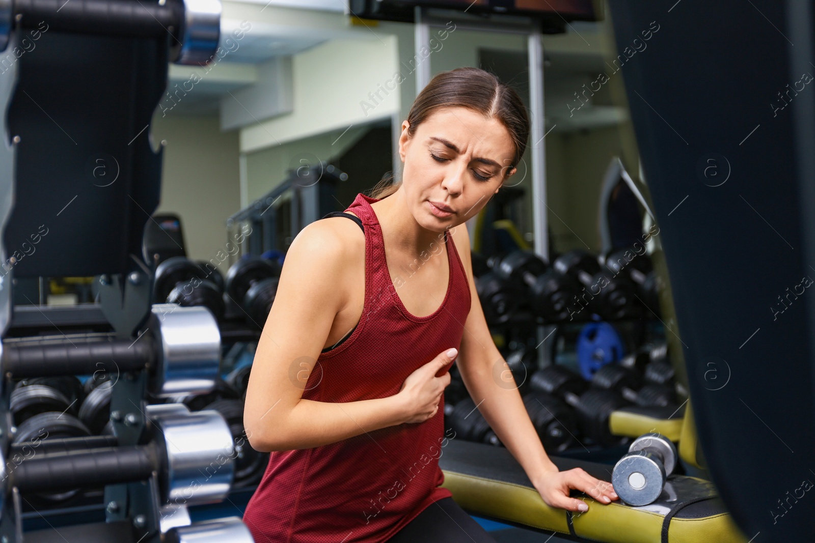 Photo of Young woman having heart attack in gym