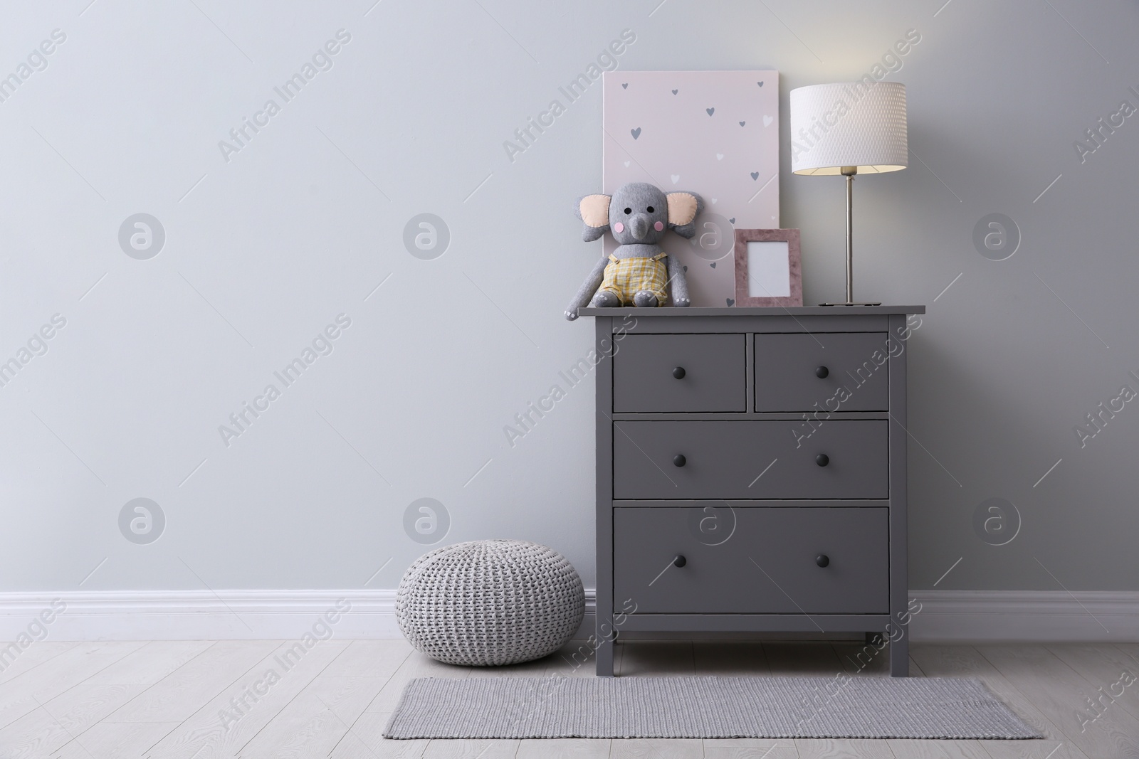 Photo of Modern grey chest of drawers near light wall in child room, space for text. Interior design