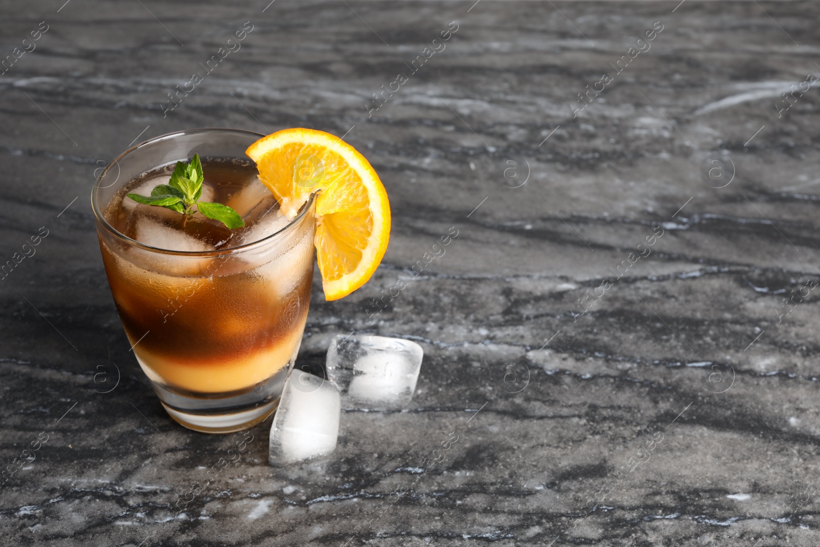 Photo of Tasty refreshing drink with coffee and orange juice on grey marble table, space for text