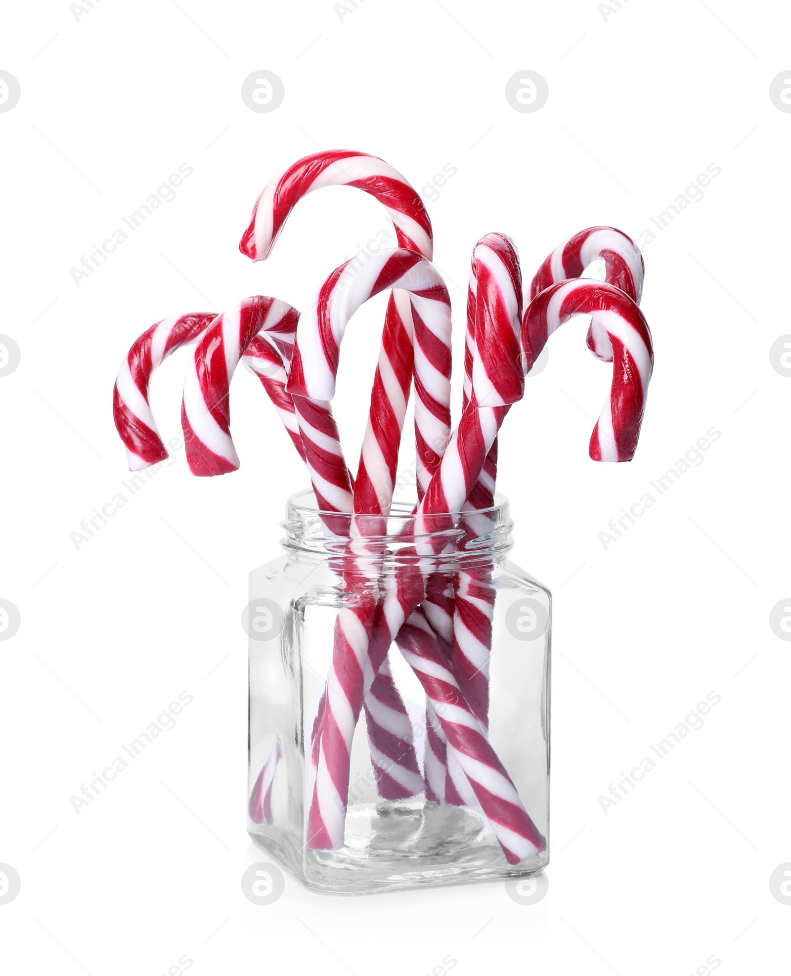 Photo of Sweet Christmas candy canes in glass jar on white background