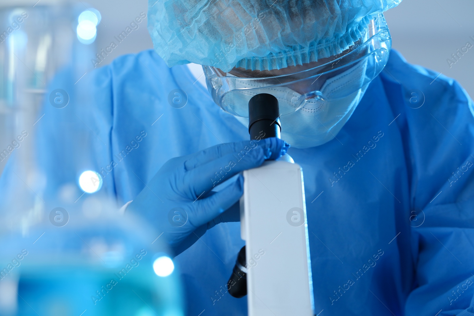 Photo of Scientist working with microscope in laboratory, closeup. Medical research