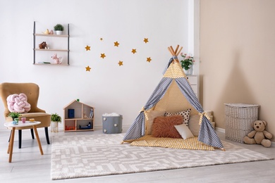 Photo of Cozy kids room interior with play tent and toys