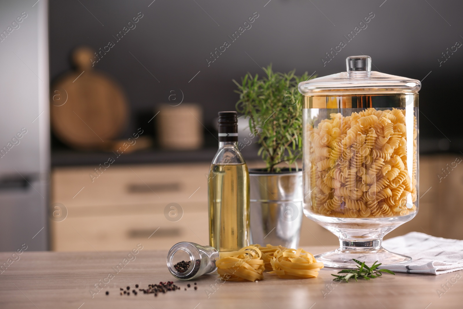 Photo of Raw pasta on wooden table in modern kitchen