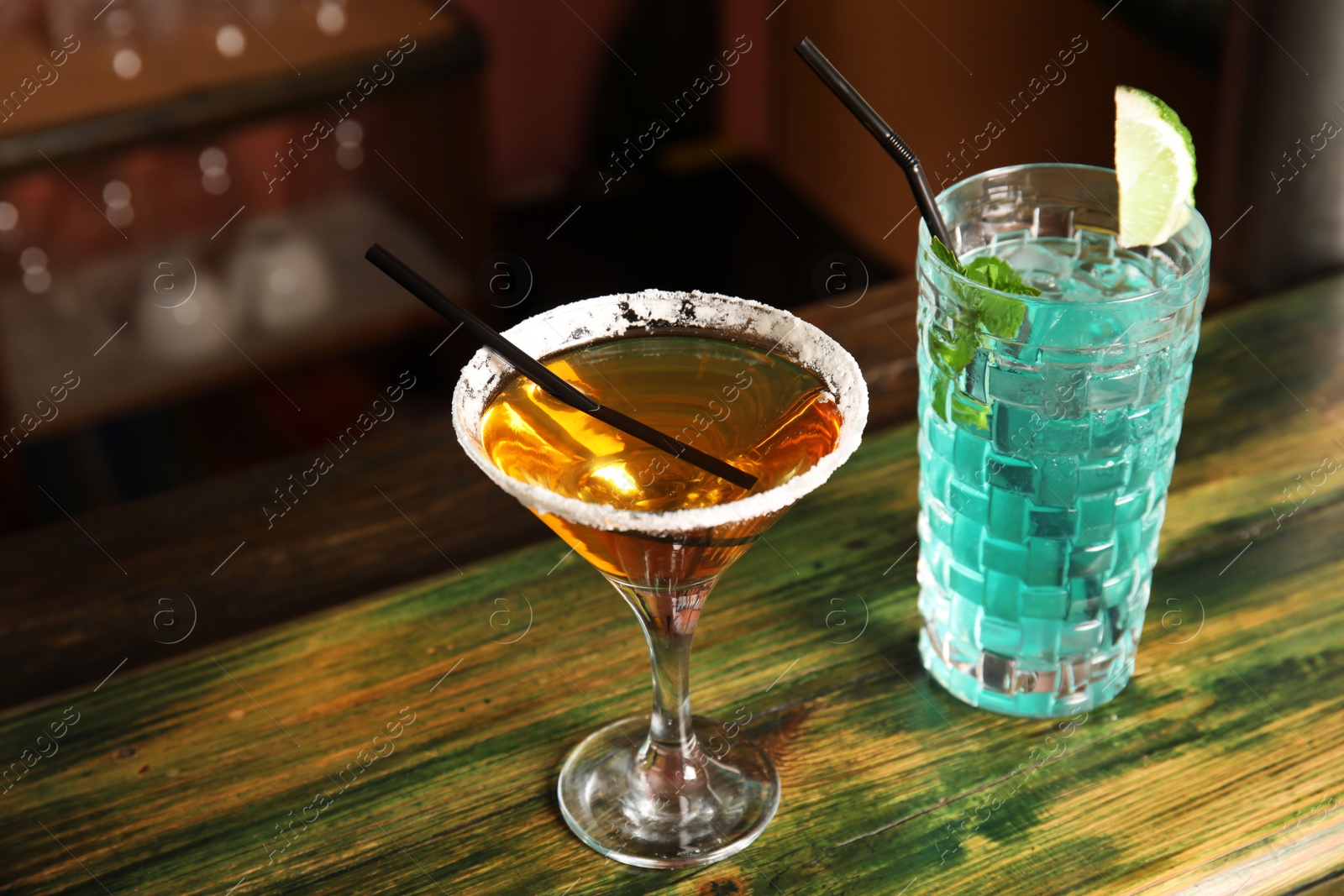 Photo of Glasses with delicious cocktails on counter in bar