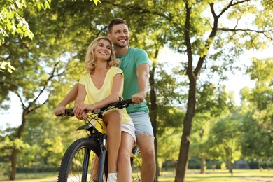 Lovely couple with bicycle in park on sunny day