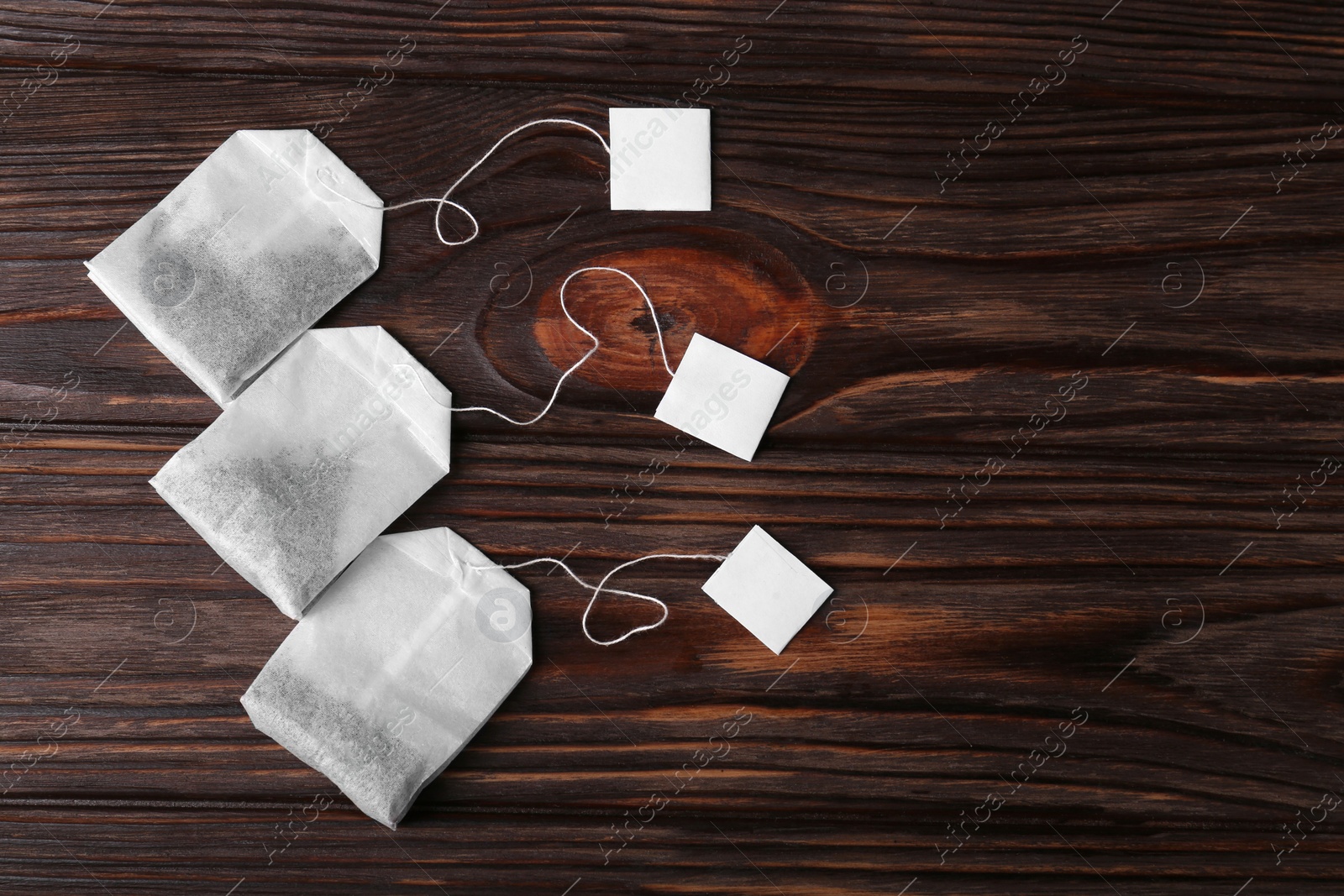 Photo of Tea bags on wooden table, flat lay. Space for text