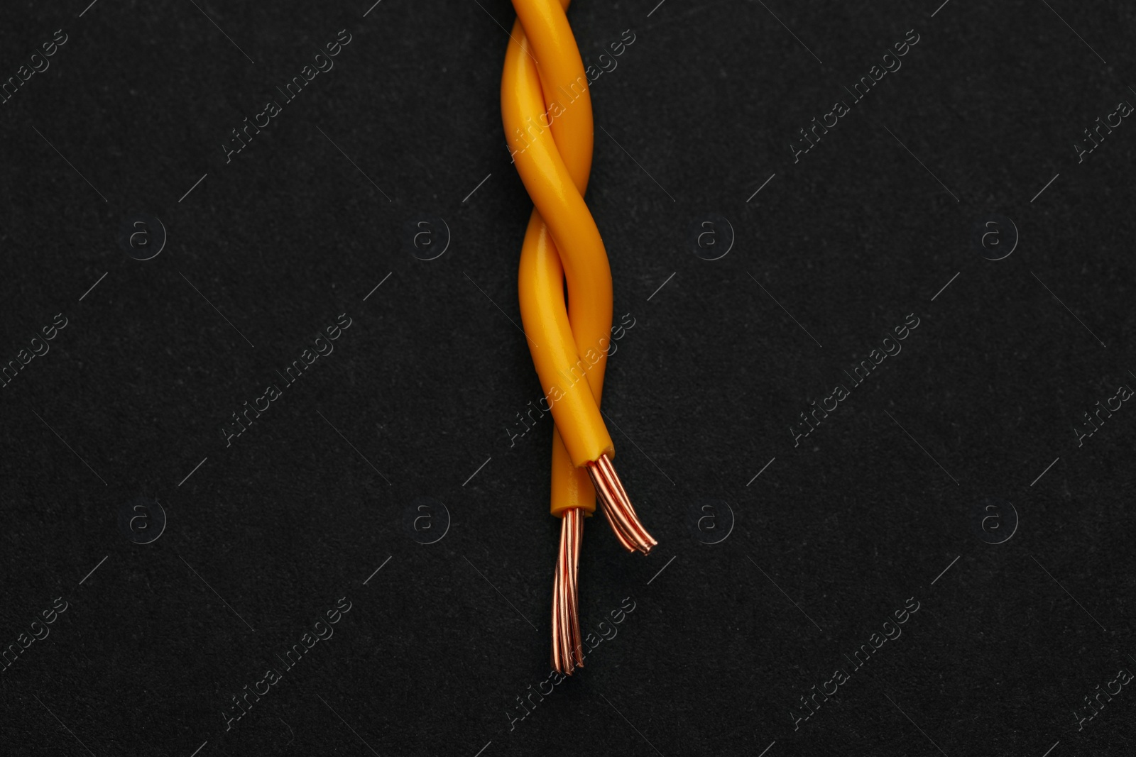 Photo of Yellow electrical wires on black background, top view