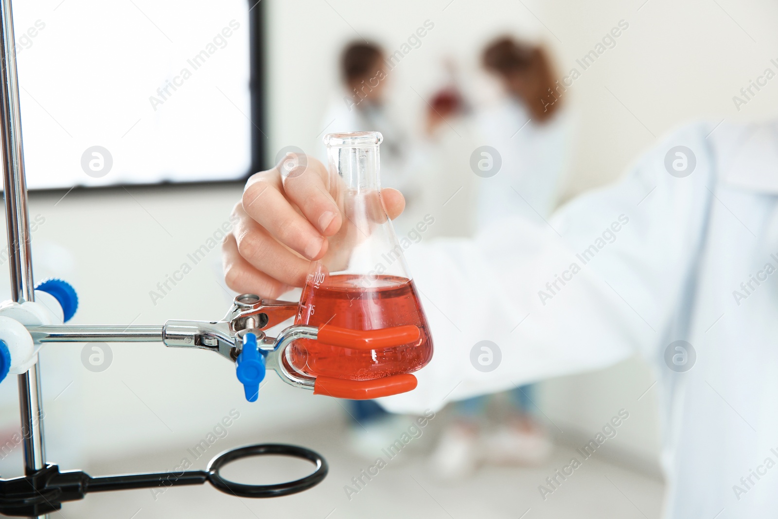Photo of Pupil holding flask with reagent in chemistry class, closeup