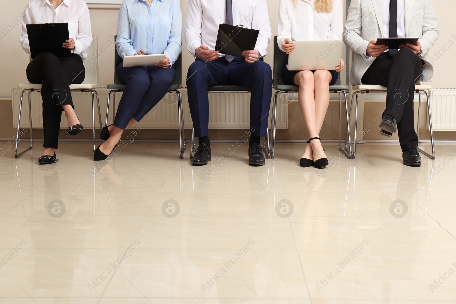 Photo of People waiting for job interview in office hall, closeup