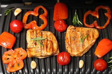 Photo of Tasty meat, spices and vegetables on electric grill, closeup