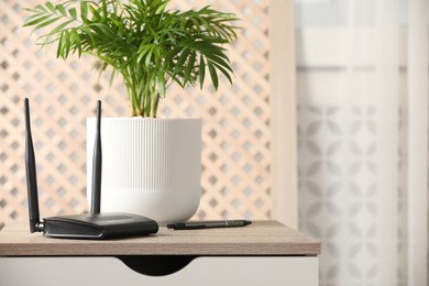 Photo of Modern Wi-Fi router indoors. Space for text