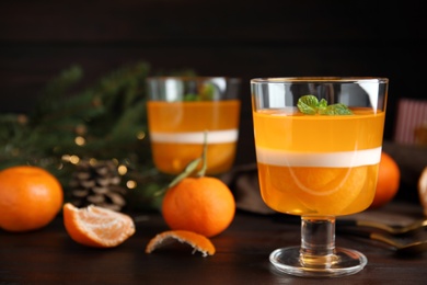 Photo of Delicious tangerine jelly on brown wooden table
