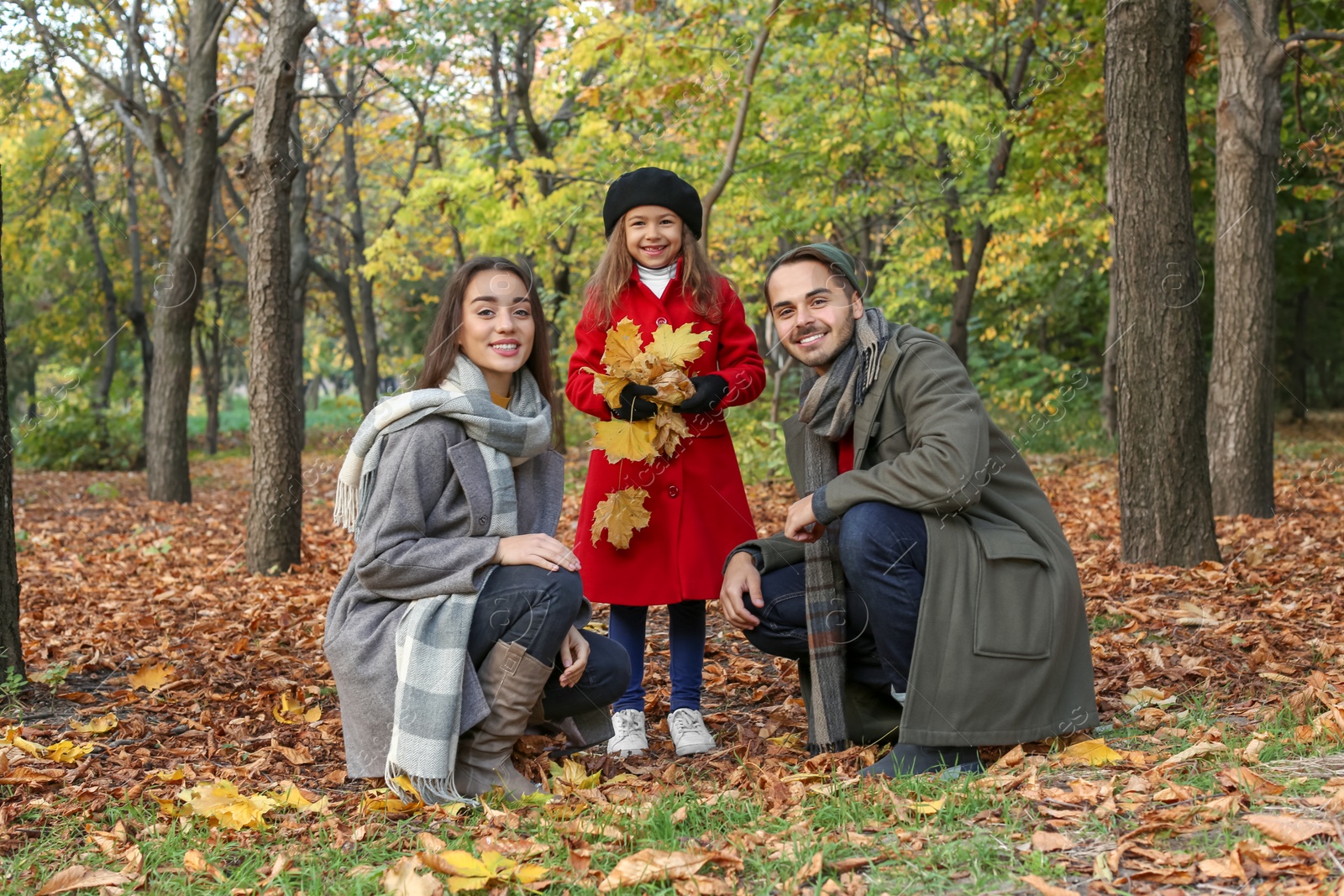 Photo of Happy family with child spending time together in park. Autumn walk