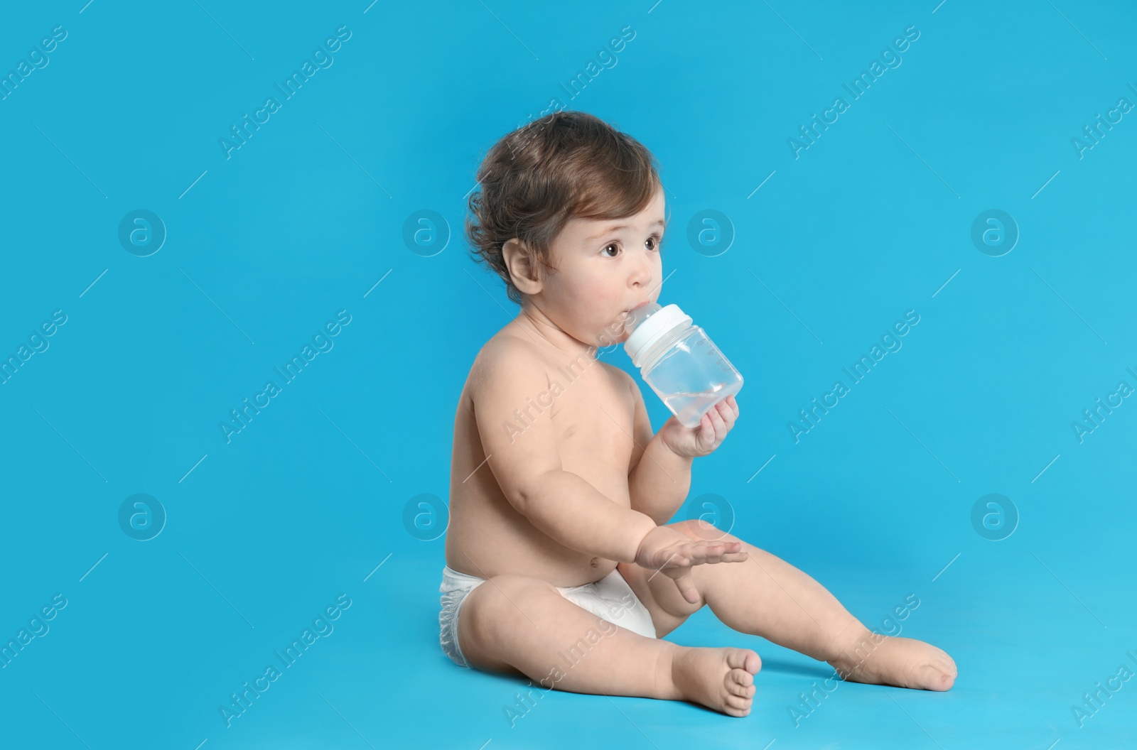 Photo of Cute little baby in diaper on light blue background