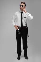 Male security guard in uniform on color background