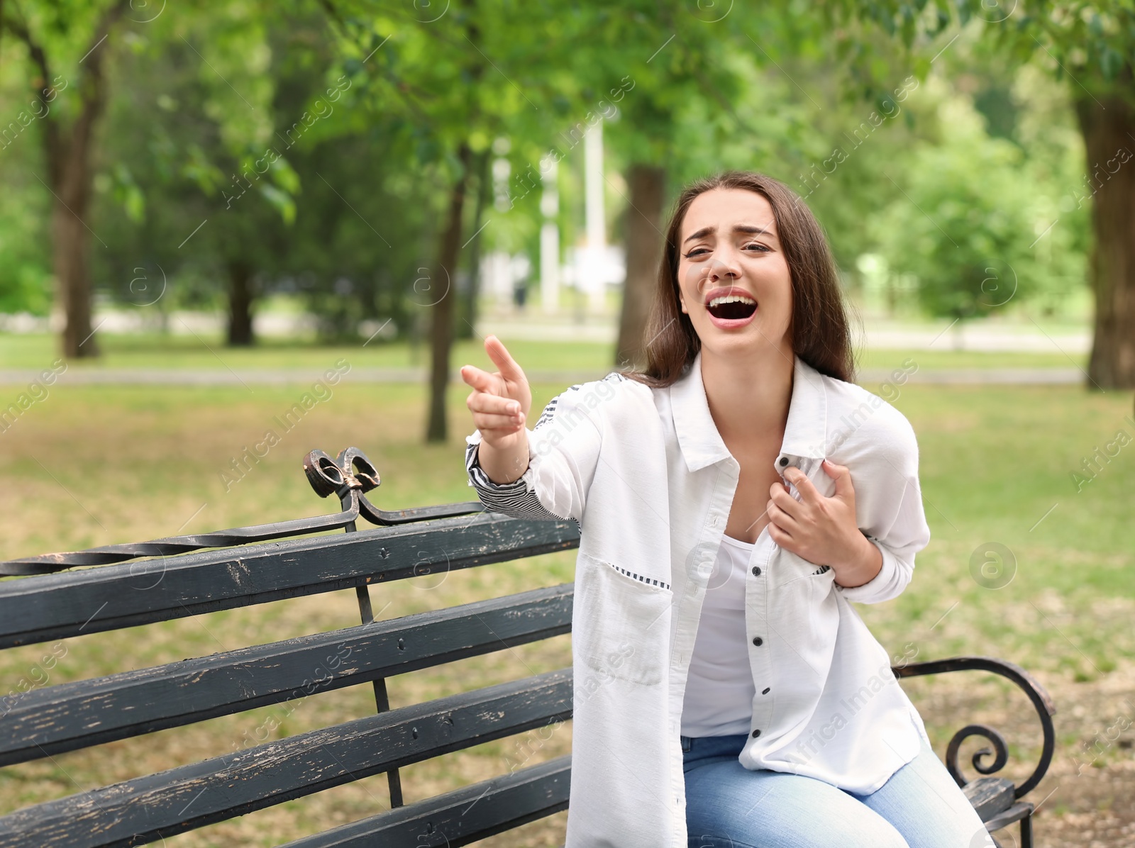 Photo of Young woman asking for help while having heart attack in park