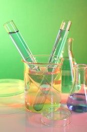 Laboratory analysis. Different glassware on table against color background