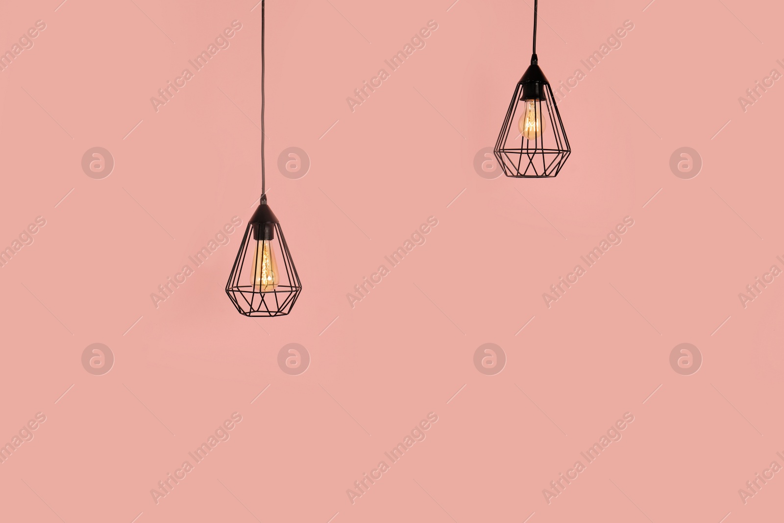 Photo of Modern hanging lamps on color background, space for text. Idea for interior design