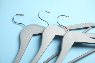 Photo of Empty wooden hangers on color background, closeup