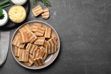 Delicious pita chips and sauce on grey table, flat lay. Space for text