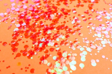 Photo of Shiny bright red glitter on pale coral background