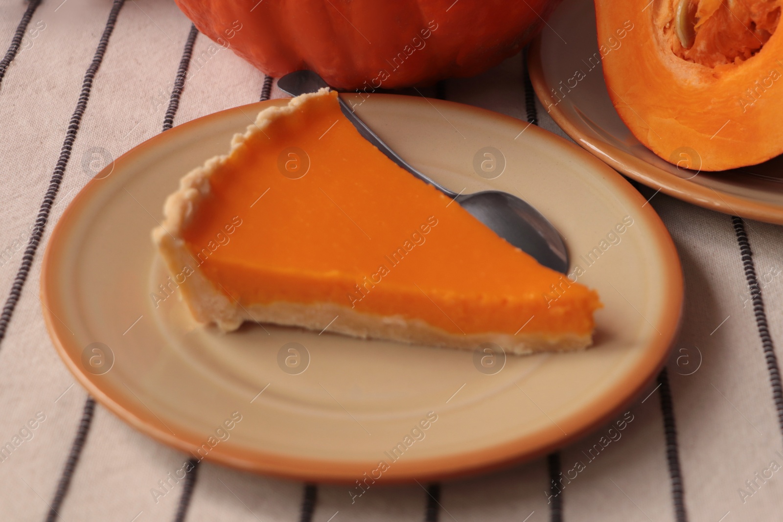 Photo of Plate with piece of fresh homemade pumpkin pie on table