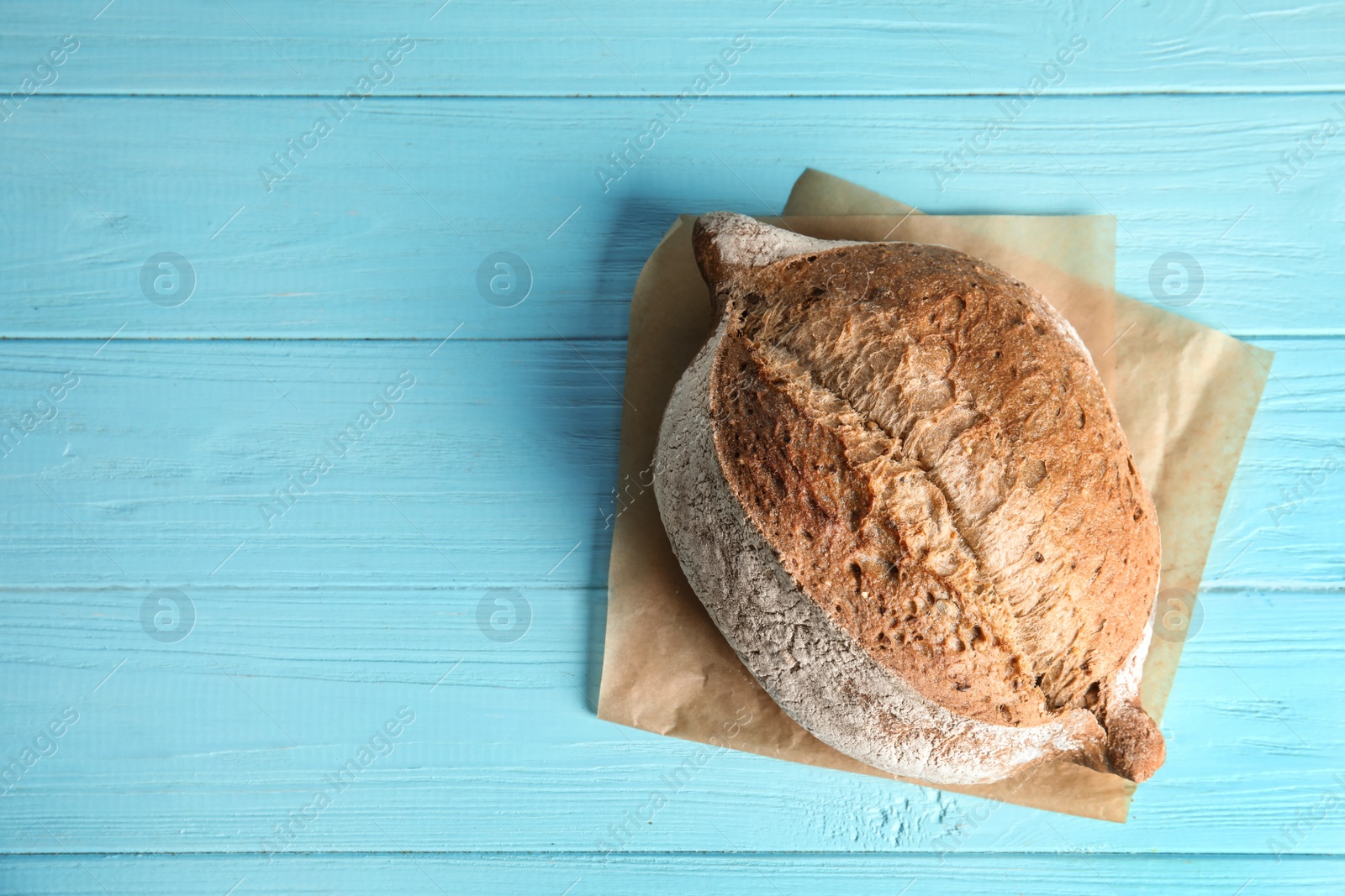 Photo of Fresh bread on color wooden background, top view with space for text