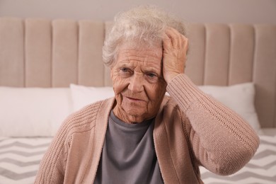 Photo of Senior woman with headache in bedroom at home