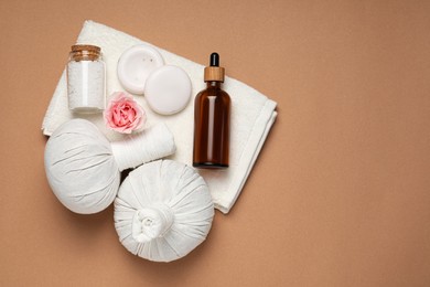 Flat lay composition of herbal bags and spa products on light brown background, space for text