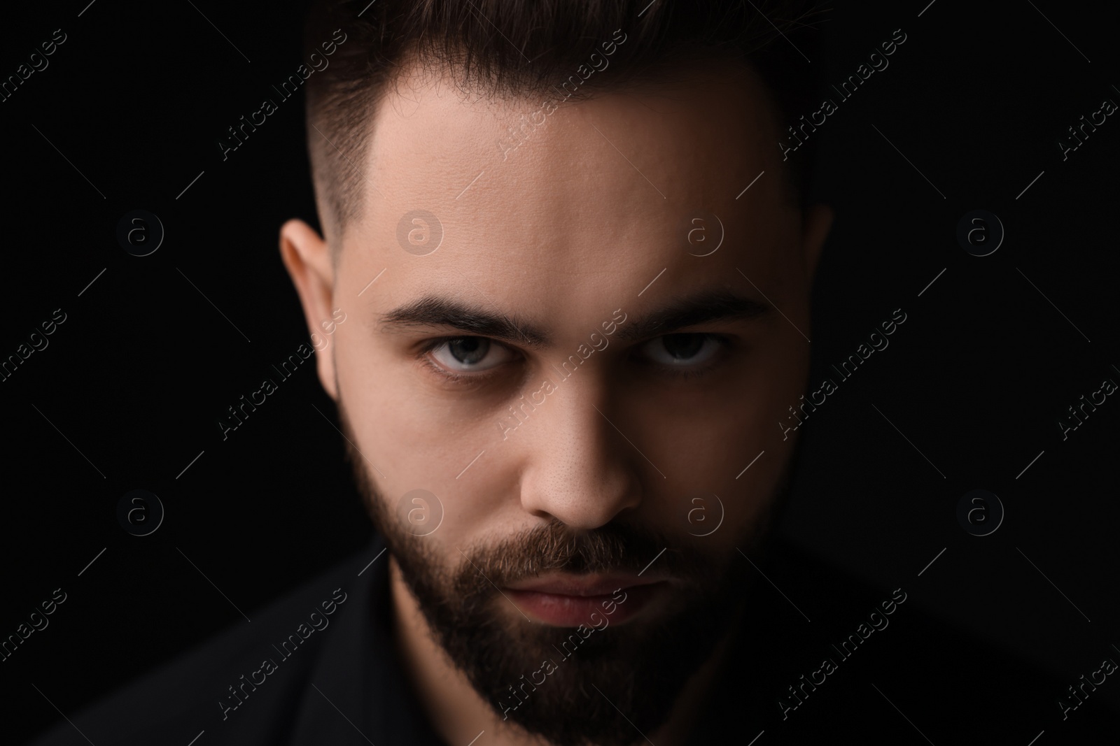 Photo of Evil eye. Man with scary eyes on black background