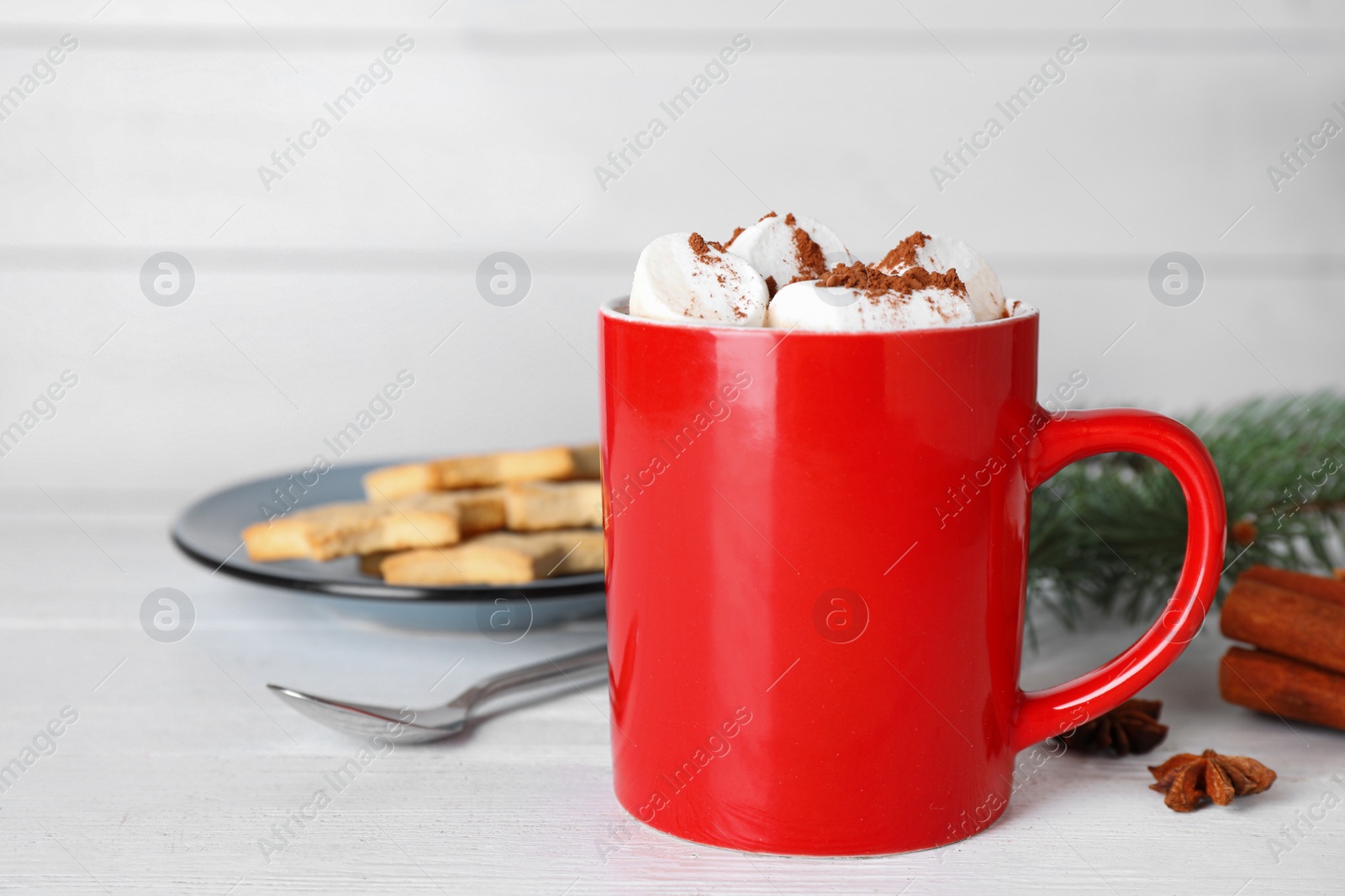 Photo of Composition of tasty cocoa with marshmallows in cup on white wooden table